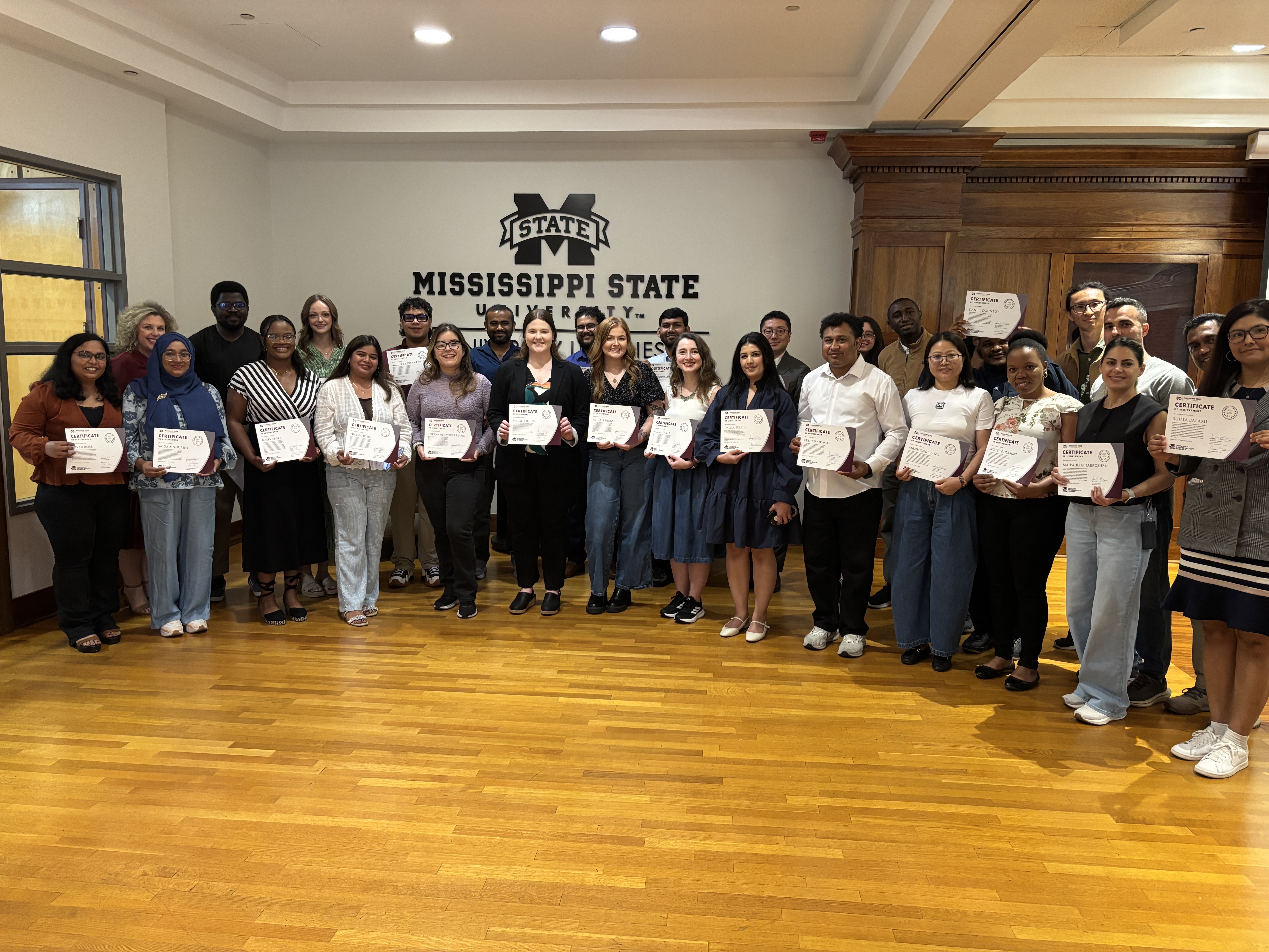 Group photo of the PFF Graduates for academic year 2025-2026. Graduates are grouped together proudly holding their certificates of completion.